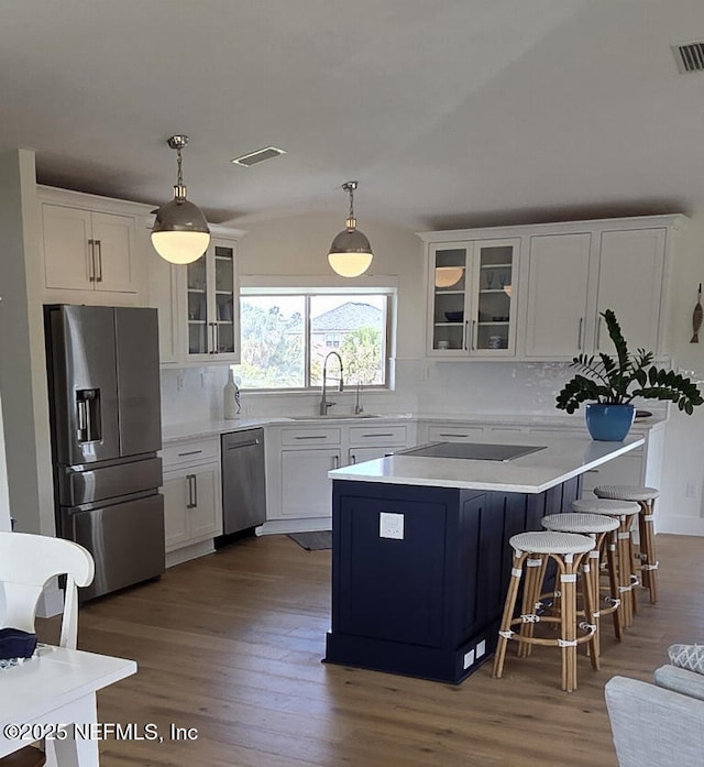 7 Sabor De Sal Rd, Saint Augustine, FL 32080 - kitchen with stainless steel appliances, wood finished floors, white cabinetry, and backsplash