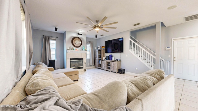 2032 Trailing Pines Way, Fleming Island, FL 32003 - living area with light tile patterned floors, ceiling fan, stairway, a tile fireplace, and baseboards