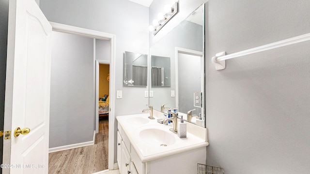 2032 Trailing Pines Way, Fleming Island, FL 32003 - bathroom with wood finished floors, double vanity, and connected bathroom