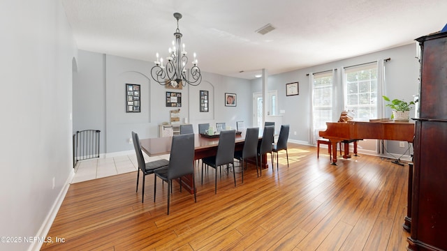 2032 Trailing Pines Way, Fleming Island, FL 32003 - dining space with a chandelier, light wood-style flooring, baseboards, and arched walkways