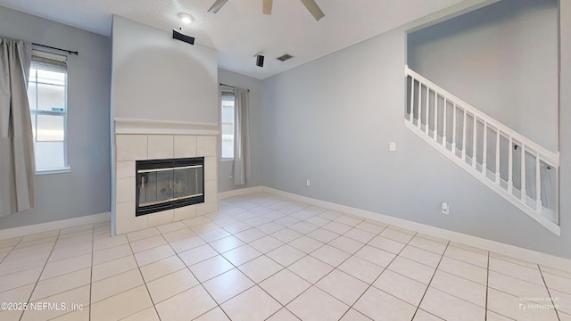2032 Trailing Pines Way, Fleming Island, FL 32003 - unfurnished living room with stairway, ceiling fan, a tiled fireplace, and baseboards