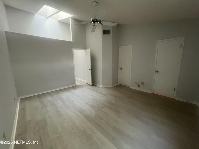 1535 Summer Sands Dr, Neptune Beach, FL 32266 - empty room with a skylight, light wood finished floors, ceiling fan, and a towering ceiling