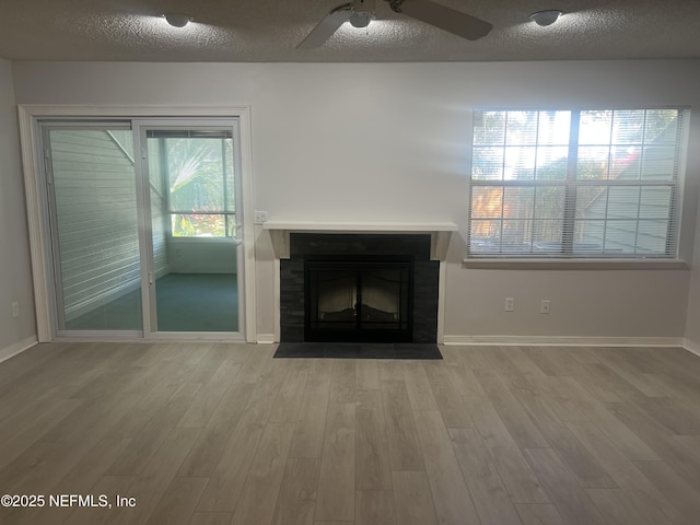 1535 Summer Sands Dr, Neptune Beach, FL 32266 - unfurnished living room with a fireplace with flush hearth, a textured ceiling, ceiling fan, and wood finished floors