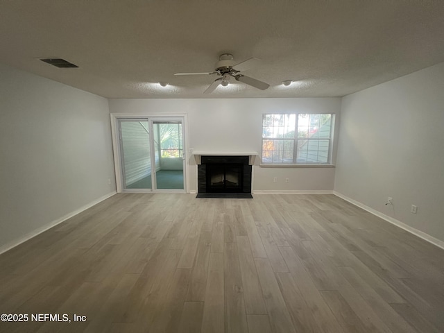 1535 Summer Sands Dr, Neptune Beach, FL 32266 - unfurnished living room with a ceiling fan, wood finished floors, a fireplace with flush hearth, and healthy amount of natural light