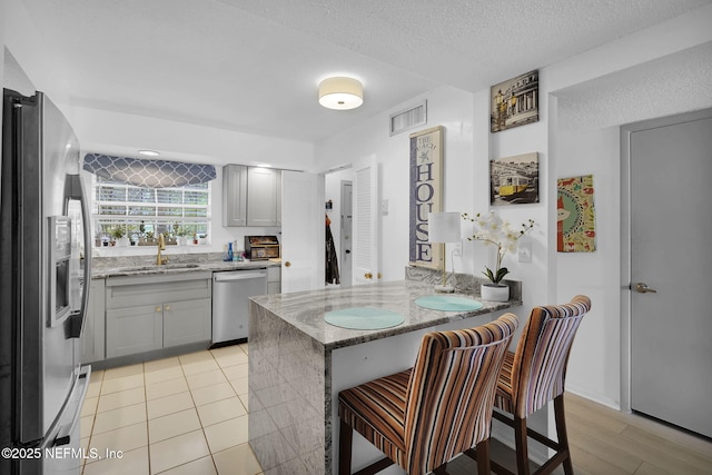 9901 Regency Square Blvd Unit 90, Jacksonville, FL 32225 - kitchen featuring appliances with stainless steel finishes, a sink, light stone counters, a peninsula, and a kitchen breakfast bar