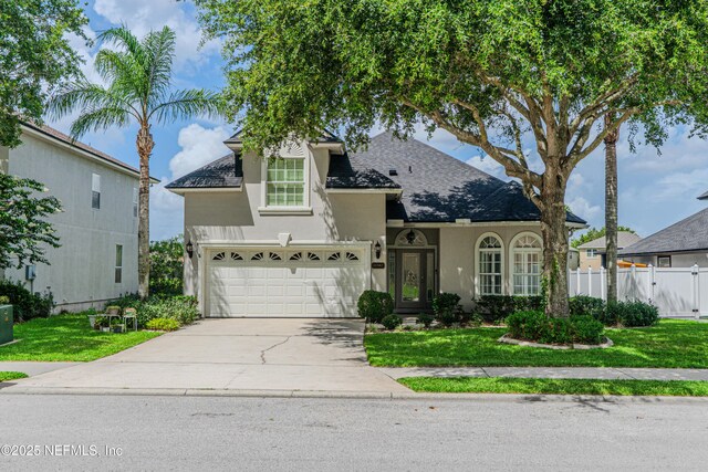 11582 Wynnfield Lakes Cir, Jacksonville, FL 32246 - view of front facade featuring stucco siding, concrete driveway, roof with shingles, and an attached garage
