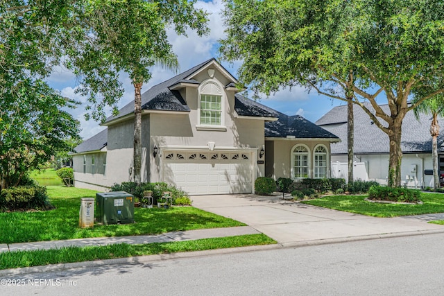 11582 Wynnfield Lakes Cir, Jacksonville, FL 32246 - view of front facade featuring stucco siding, driveway, a front yard, a garage, and roof with shingles