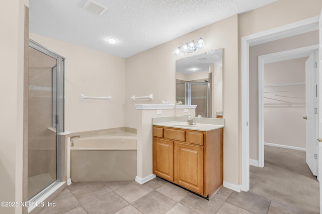 11582 Wynnfield Lakes Cir, Jacksonville, FL 32246 - bathroom featuring a bath, a stall shower, a spacious closet, vanity, and a textured ceiling