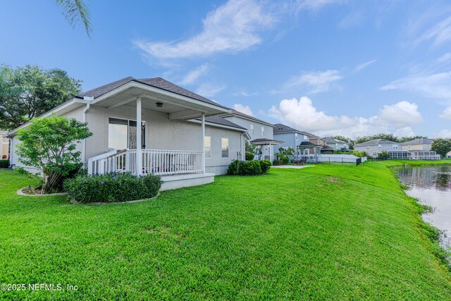 11582 Wynnfield Lakes Cir, Jacksonville, FL 32246 - view of grassy yard with covered porch, a residential view, and a water view
