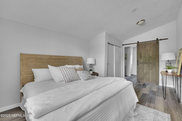 9076 1st Ave, Jacksonville, FL 32208 - bedroom with a barn door, wood finished floors, a textured ceiling, and a closet