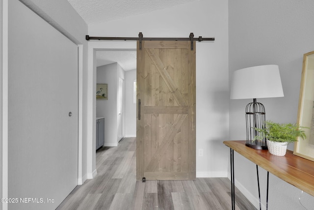 9076 1st Ave, Jacksonville, FL 32208 - hall with wood finished floors, a barn door, a textured ceiling, and vaulted ceiling