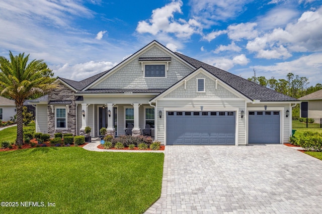 95158 Sandy Pointe Dr, Fernandina Beach, FL 32034 - craftsman inspired home featuring a front yard, decorative driveway, a garage, and a porch