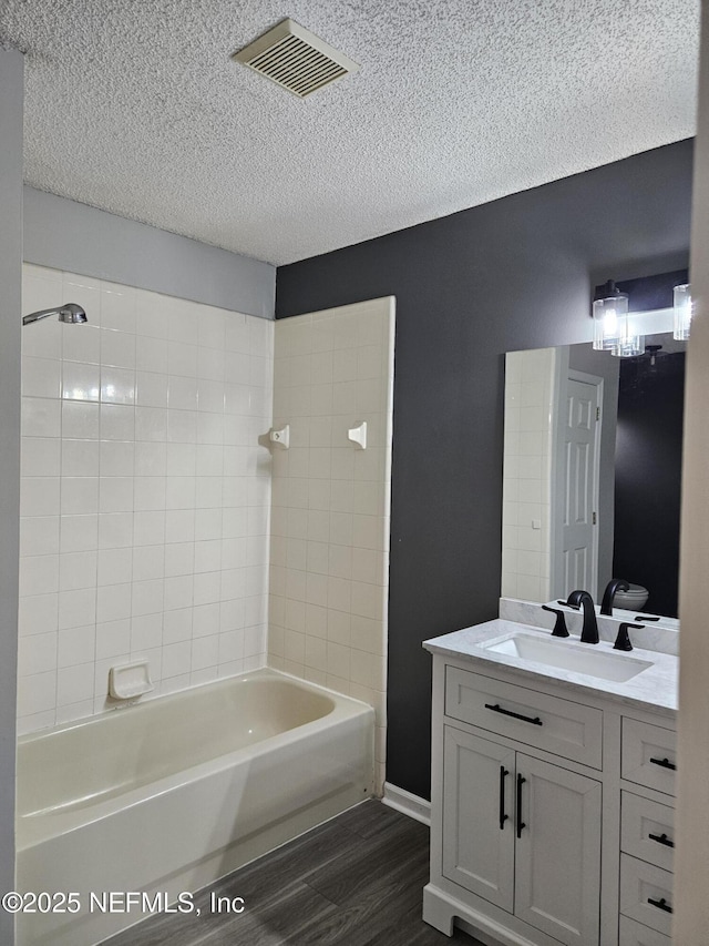 1203 Stern Way, Fleming Island, FL 32003 - full bathroom with wood finished floors, vanity, a textured ceiling, and washtub / shower combination
