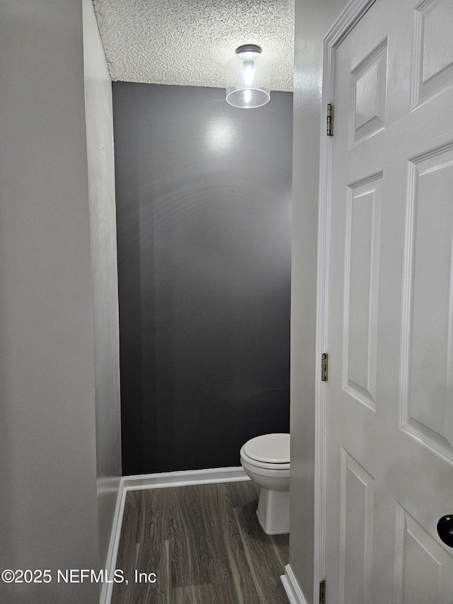 1203 Stern Way, Fleming Island, FL 32003 - bathroom with toilet, wood finished floors, a textured ceiling, and baseboards