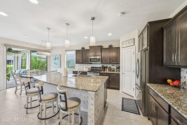 600 Broomsedge Cir, Saint Augustine, FL 32095 - kitchen featuring stainless steel appliances, tasteful backsplash, dark brown cabinets, light stone countertops, and recessed lighting