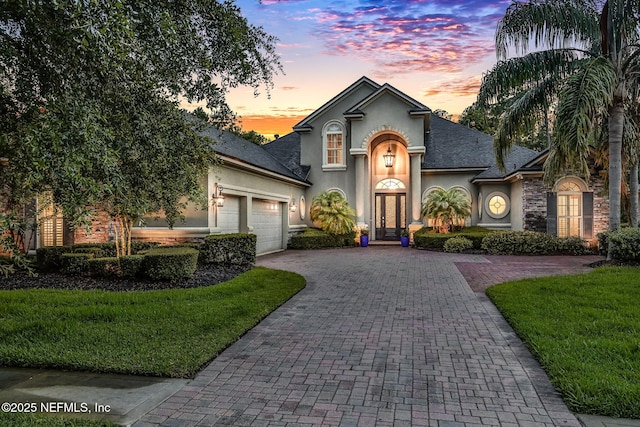528 Sebastian Sq, Saint Augustine, FL 32095 - view of front of home featuring a garage, stucco siding, decorative driveway, a front lawn, and stone siding