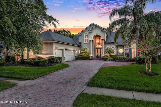 528 Sebastian Sq, Saint Augustine, FL 32095 - view of front facade featuring stucco siding, an attached garage, decorative driveway, and a front lawn
