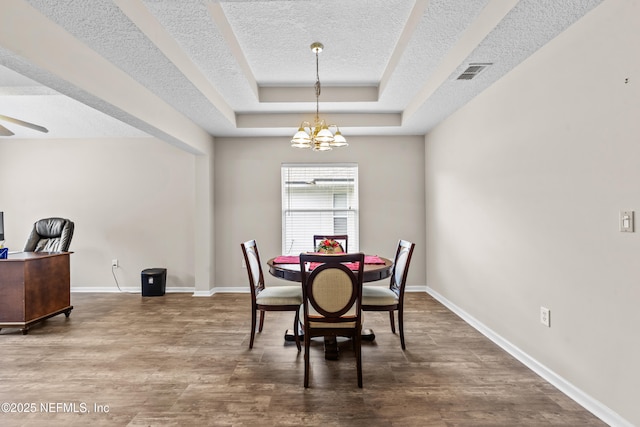 1861 Heartpine Dr, Middleburg, FL 32068 - dining area with a textured ceiling, a raised ceiling, a chandelier, and wood finished floors