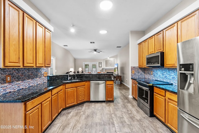 1861 Heartpine Dr, Middleburg, FL 32068 - kitchen featuring stainless steel appliances, a ceiling fan, a peninsula, light wood-type flooring, and decorative backsplash
