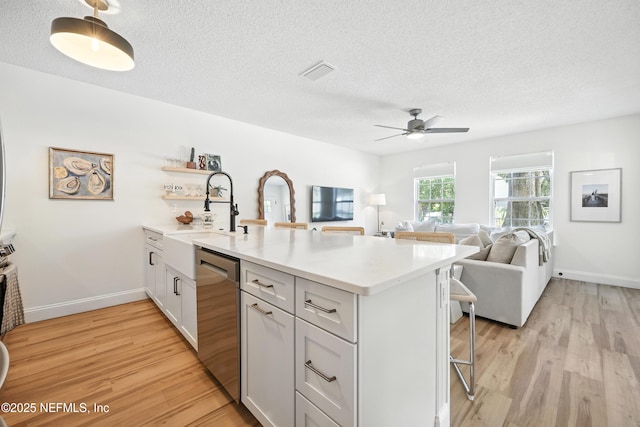 1848 Forsyth Ct, Atlantic Beach, FL 32233 - kitchen with dishwasher, a peninsula, a breakfast bar area, light wood finished floors, and light countertops