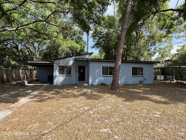 6115 Suwanee Rd, Jacksonville, FL 32217 - view of front of property featuring stucco siding, a carport, and driveway