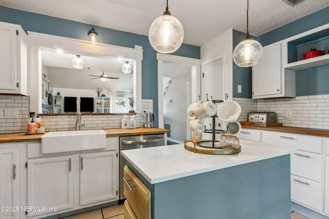 11461 Willet Ct S, Jacksonville, FL 32225 - kitchen with wooden counters, tasteful backsplash, ceiling fan, white cabinets, and a textured ceiling