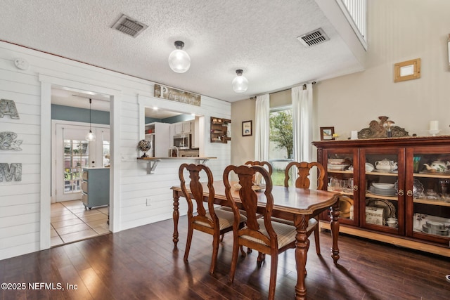 11461 Willet Ct S, Jacksonville, FL 32225 - dining space featuring wood finished floors, wooden walls, and a textured ceiling