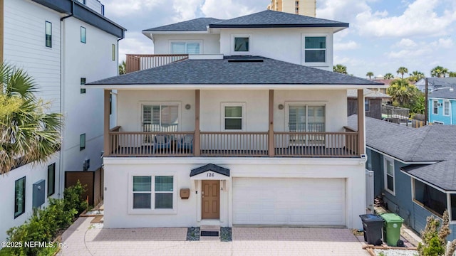 126 1st St S, Jacksonville Beach, FL 32250 - view of front facade with stucco siding, a shingled roof, driveway, and a balcony