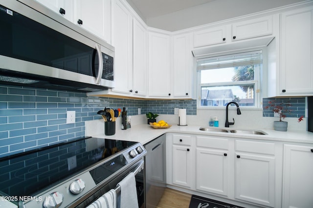 126 1st St S, Jacksonville Beach, FL 32250 - kitchen featuring stainless steel appliances, a sink, decorative backsplash, and white cabinets