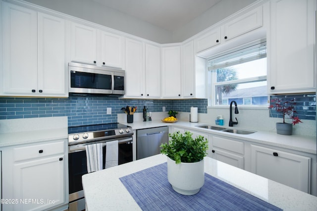 126 1st St S, Jacksonville Beach, FL 32250 - kitchen featuring appliances with stainless steel finishes, a sink, white cabinets, and decorative backsplash