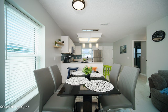 126 1st St S, Jacksonville Beach, FL 32250 - dining area featuring light marble finish flooring and a textured ceiling