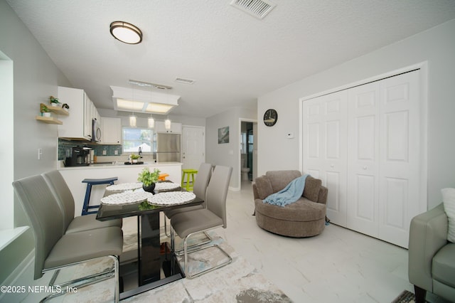 126 1st St S, Jacksonville Beach, FL 32250 - dining room featuring light marble finish flooring and a textured ceiling