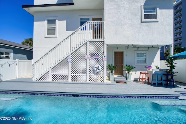 126 1st St S, Jacksonville Beach, FL 32250 - rear view of property featuring stucco siding, a patio, and stairs
