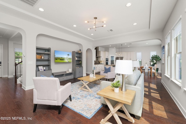 186 Citrus Ridge Dr, Ponte Vedra, FL 32081 - living area with arched walkways, a chandelier, built in shelves, dark wood-style flooring, and recessed lighting