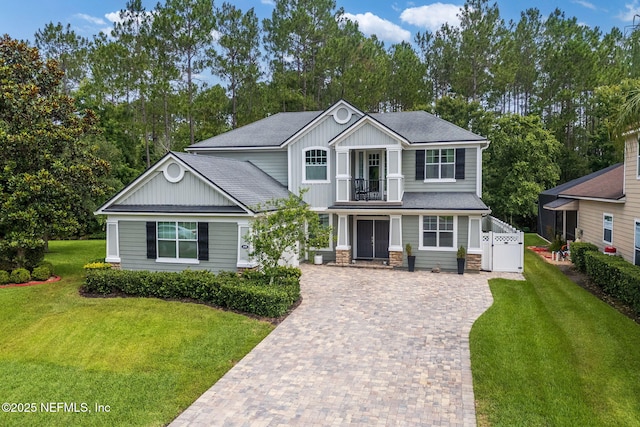 448 Willow Winds Pkwy, Saint Johns, FL 32259 - view of front of home featuring a balcony, driveway, a shingled roof, stone siding, and view of scattered trees