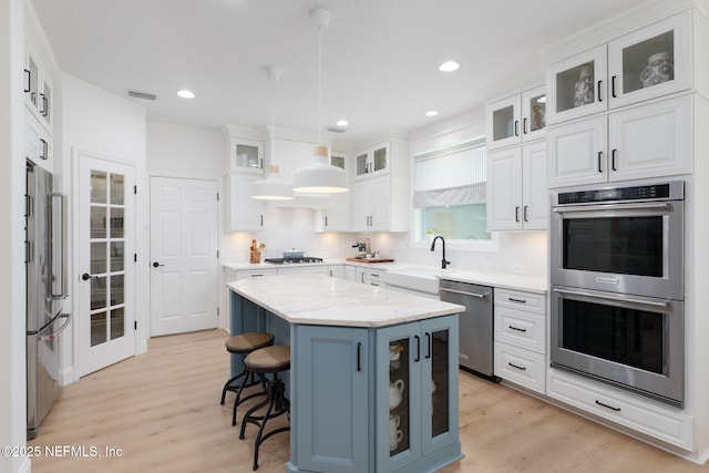 448 Willow Winds Pkwy, Saint Johns, FL 32259 - kitchen with stainless steel appliances, white cabinets, light wood-style flooring, decorative backsplash, and recessed lighting