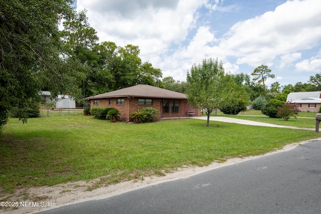 4422 SE 2nd Ave, Keystone Heights, FL 32656 - view of front facade featuring concrete driveway, a front yard, and brick siding