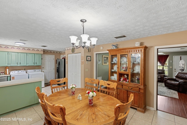 4422 SE 2nd Ave, Keystone Heights, FL 32656 - dining space featuring washer and clothes dryer, light tile patterned floors, a chandelier, and a textured ceiling