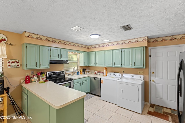 4422 SE 2nd Ave, Keystone Heights, FL 32656 - laundry room featuring washing machine and dryer, light tile patterned floors, and a textured ceiling