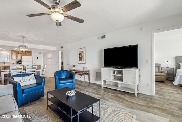 3350 Fletcher Ave Unit 6J, Fernandina Beach, FL 32034 - living area featuring light wood-style flooring, a ceiling fan, and a chandelier
