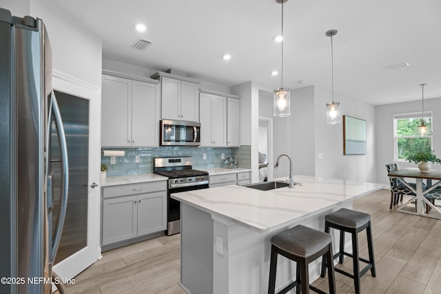 52 Key Grass Ct, Saint Johns, FL 32259 - kitchen with stainless steel appliances, light wood-style floors, decorative backsplash, light stone counters, and recessed lighting