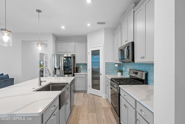 52 Key Grass Ct, Saint Johns, FL 32259 - kitchen with stainless steel appliances, backsplash, an island with sink, decorative light fixtures, and recessed lighting