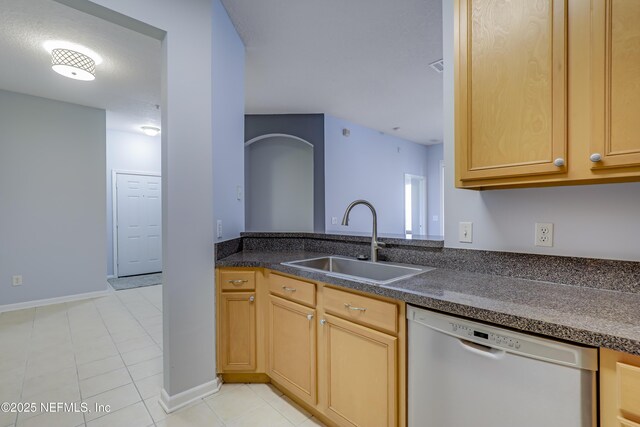 8601 Beach Blvd Unit 1008, Jacksonville, FL 32216 - kitchen with white dishwasher, light tile patterned floors, dark countertops, and light brown cabinetry