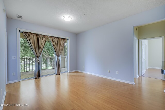 8601 Beach Blvd Unit 1008, Jacksonville, FL 32216 - unfurnished room with light wood-style floors, healthy amount of natural light, and a textured ceiling