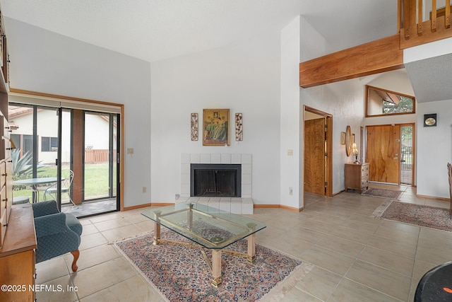 55 Village Cir, Palm Coast, FL 32164 - living area with a tile fireplace, light tile patterned floors, baseboards, and high vaulted ceiling