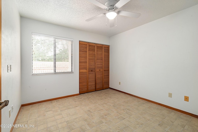 55 Village Cir, Palm Coast, FL 32164 - unfurnished bedroom with a textured ceiling, a closet, baseboards, and a ceiling fan