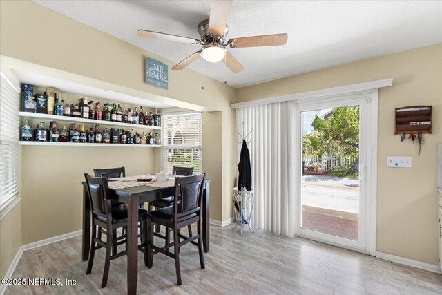 1506 Strand St, Neptune Beach, FL 32266 - dining space with wood finished floors, a ceiling fan, and a bar