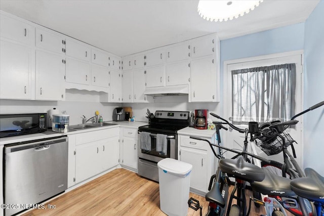 1506 Strand St, Neptune Beach, FL 32266 - kitchen featuring appliances with stainless steel finishes, under cabinet range hood, light countertops, and white cabinetry