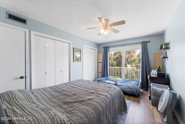 1506 Strand St, Neptune Beach, FL 32266 - bedroom featuring access to exterior, wood finished floors, two closets, a textured ceiling, and ceiling fan