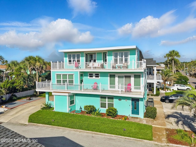 1506 Strand St, Neptune Beach, FL 32266 - view of front of property with a balcony, concrete driveway, and a front lawn